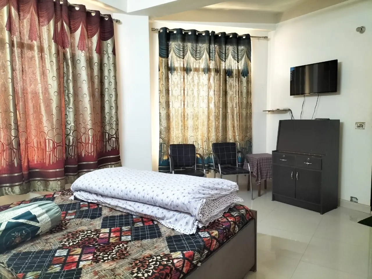 Guest room at Anupama Home Stay with double bed, wardrobe and television
