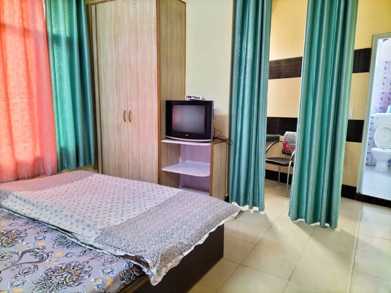 Spacious guest room at Anupama Home Stay with double bed and seating